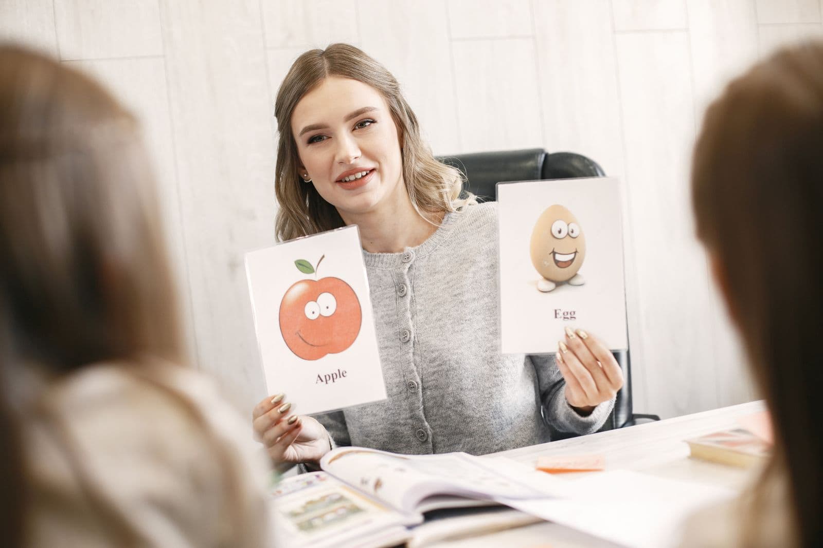 A speech therapist holding picture cards during an articulation session