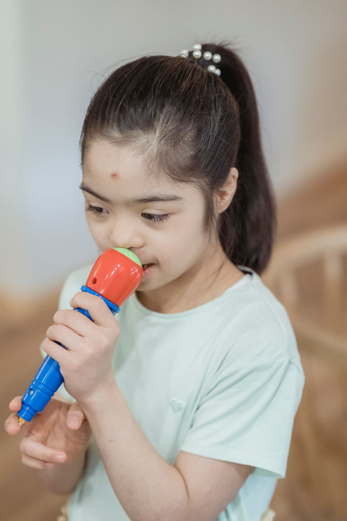 A young girl speaking into a toy microphone
